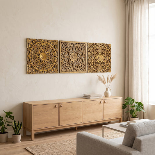 Three gold-toned carved wooden wall art panels with intricate floral and geometric patterns, displayed above a light wood sideboard in a modern, neutral-toned living room.